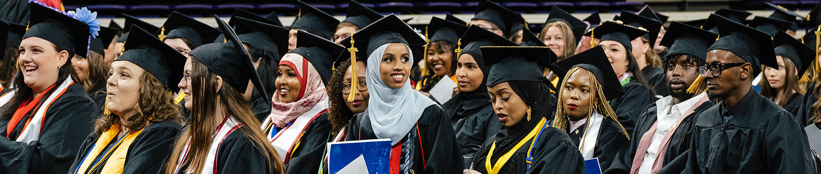 Photo of SCC students sitting in graduation gowns at commencement ceremony