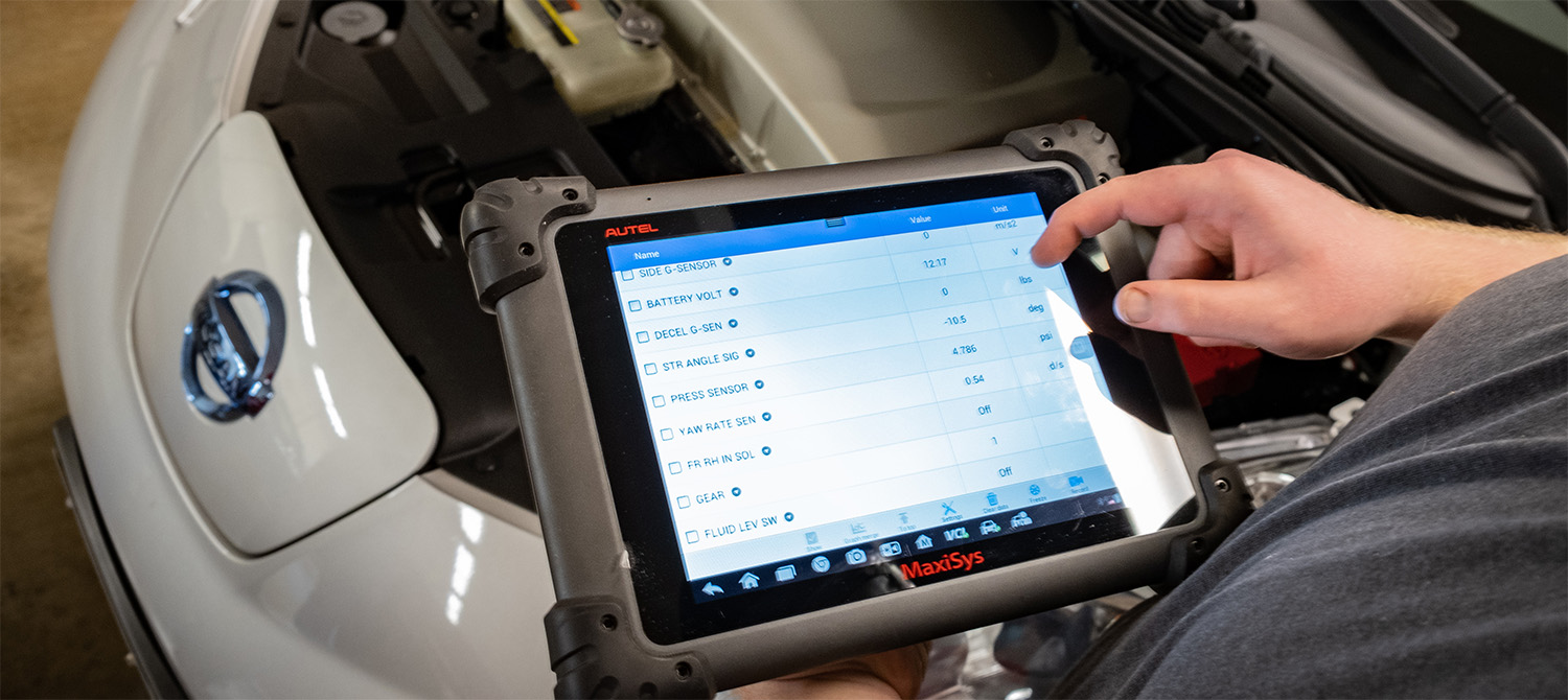Photo of auto service using a computer diagnosing scanner