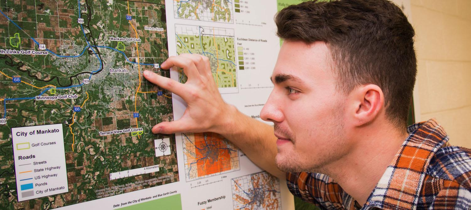 Photo of GIS student studing map