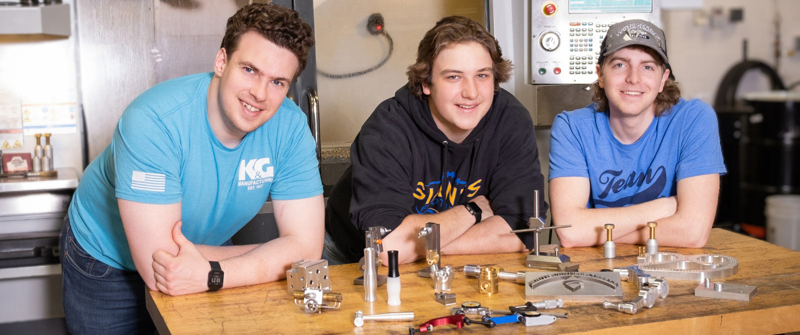Photo of MTT students around table with parts they've machined