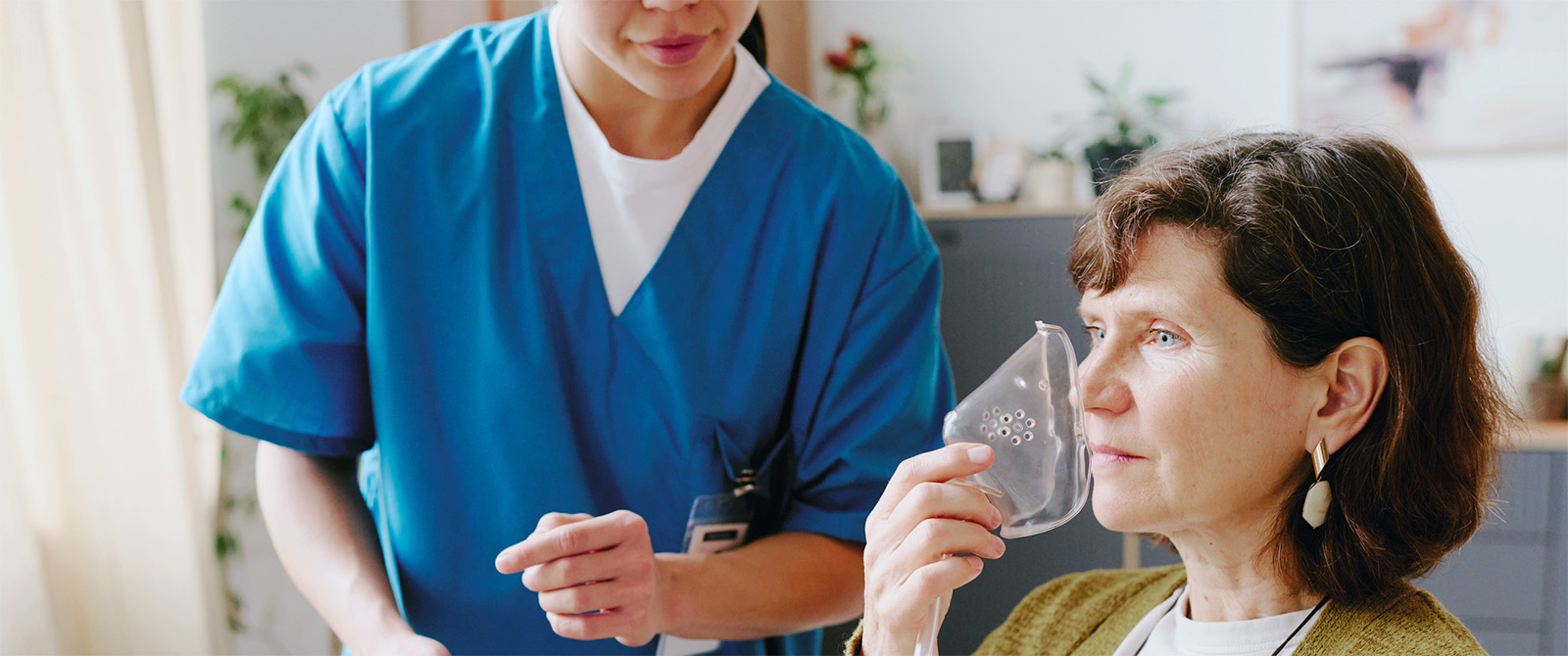 Photo of repiratory therapist working with a patient holding an oxygen mask.