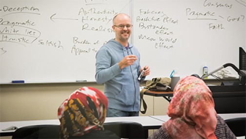 Instructor lecturing in front of a white board