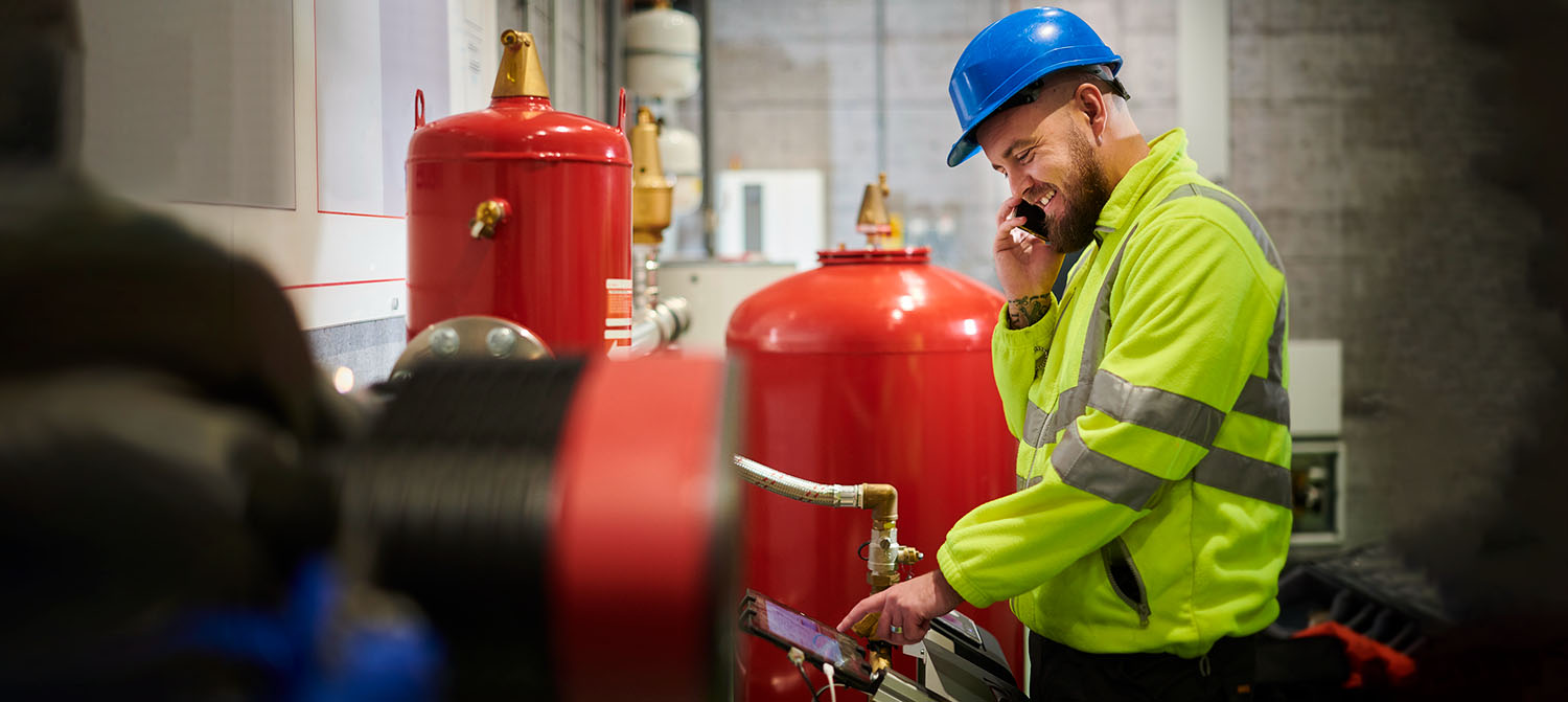Photo of boiler operator using and touch panel to manage a boiler system.