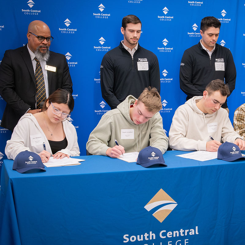Students signing enrollment agreements on Signing Day
