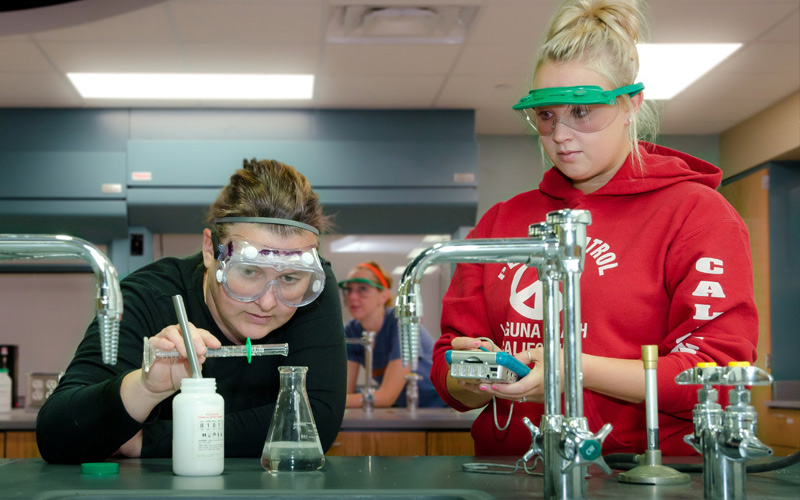 Two students in a chemistry lab participating in an experiment