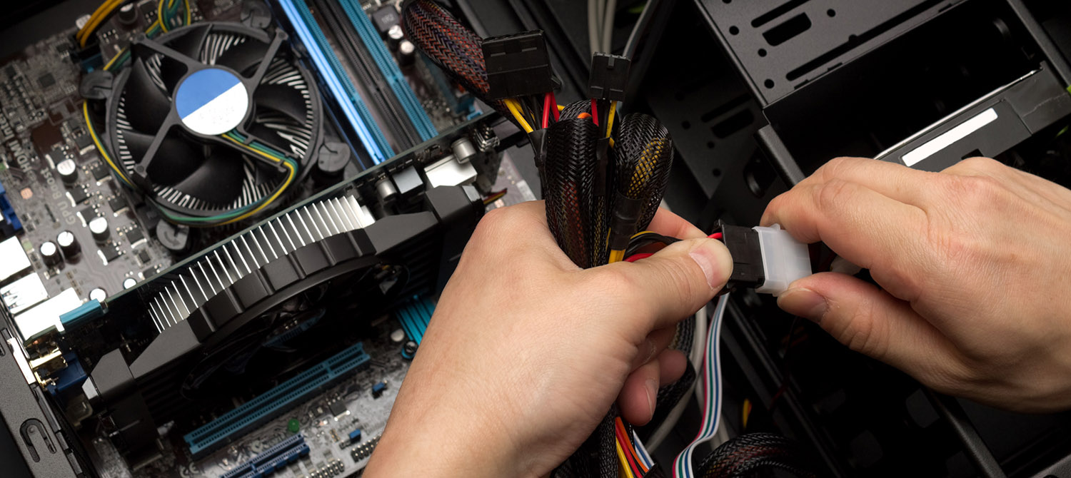 photo of a man's hands assembling cables inside a computer