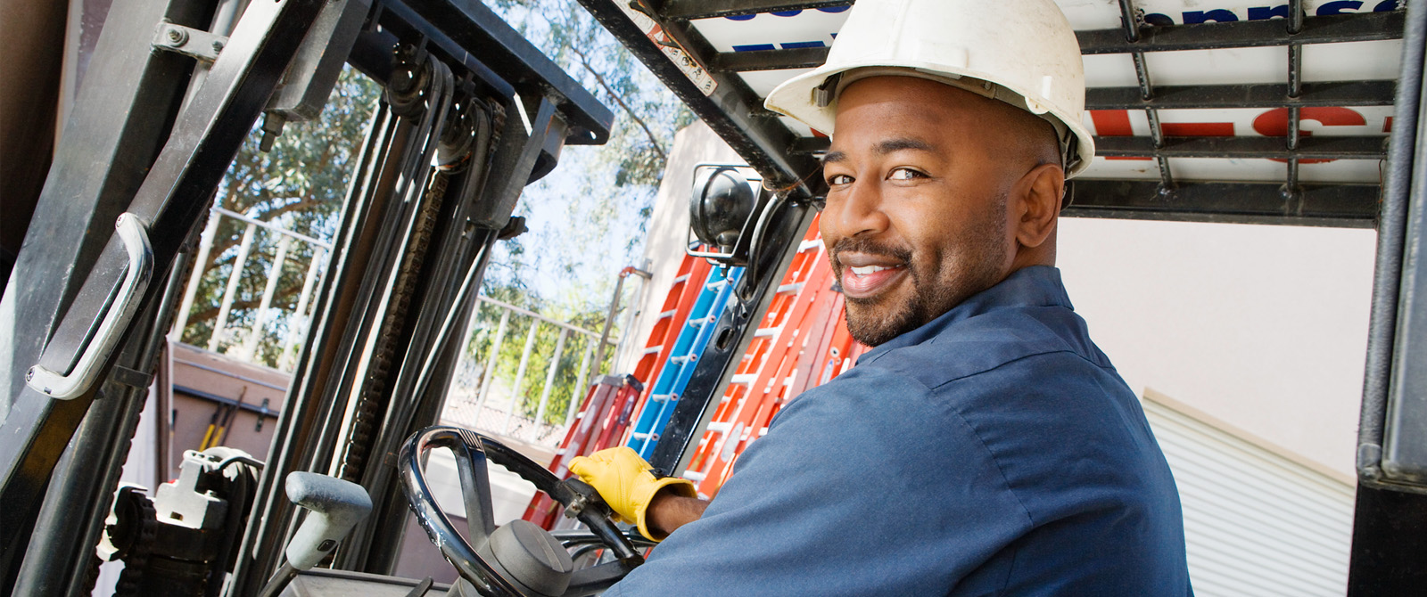Photograph of operator driving a forklift at a worksite site.