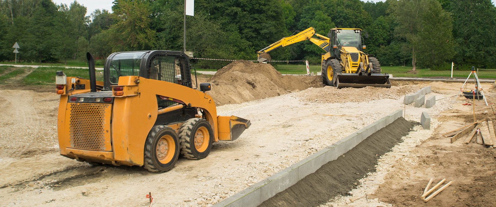 Skid steer working on construction site.
