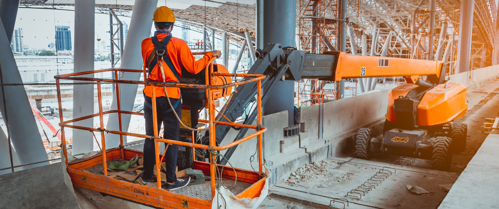 Photograph of aerial lift and operator at a construction site