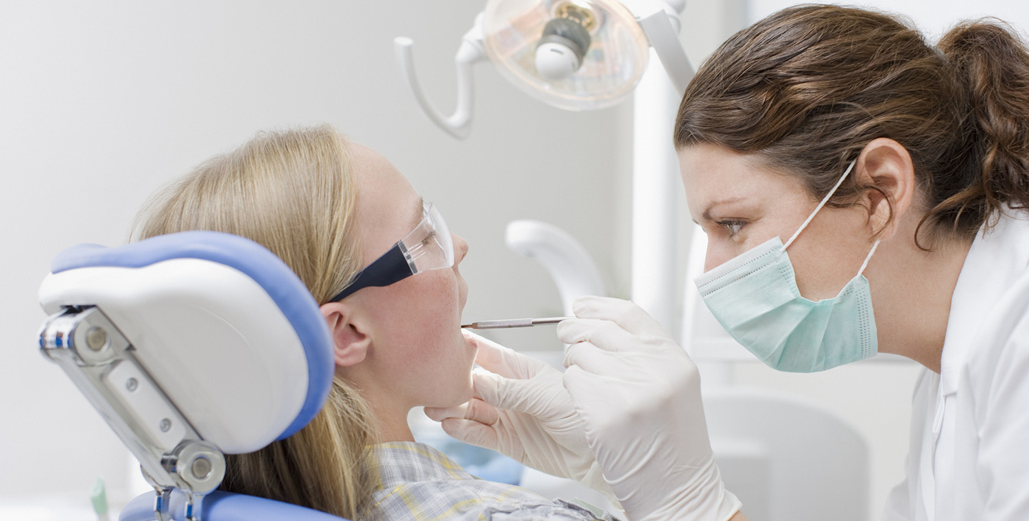 Photo of a dental assistant working on a child patient