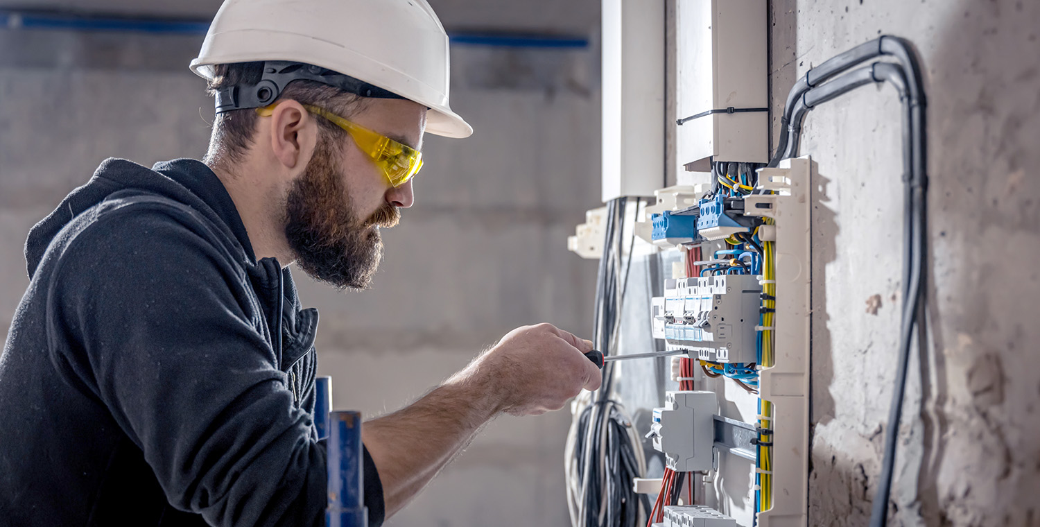 Photo of electrician working on control panel on a job site