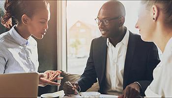 Three diverse business professionals in a discussion