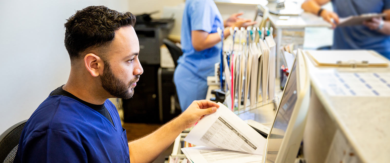 Health care worker entering data into computer